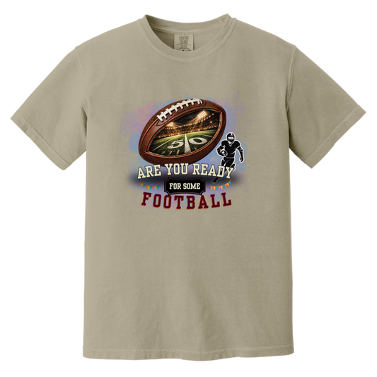 Bold football-themed graphic in Sandstone featuring a textured brown football with a glowing nighttime stadium and 50-yard line visible inside, a football player silhouette, watercolor background, and the words “ARE YOU READY FOR SOME FOOTBALL” in cream, black, and burgundy collegiate-style lettering.