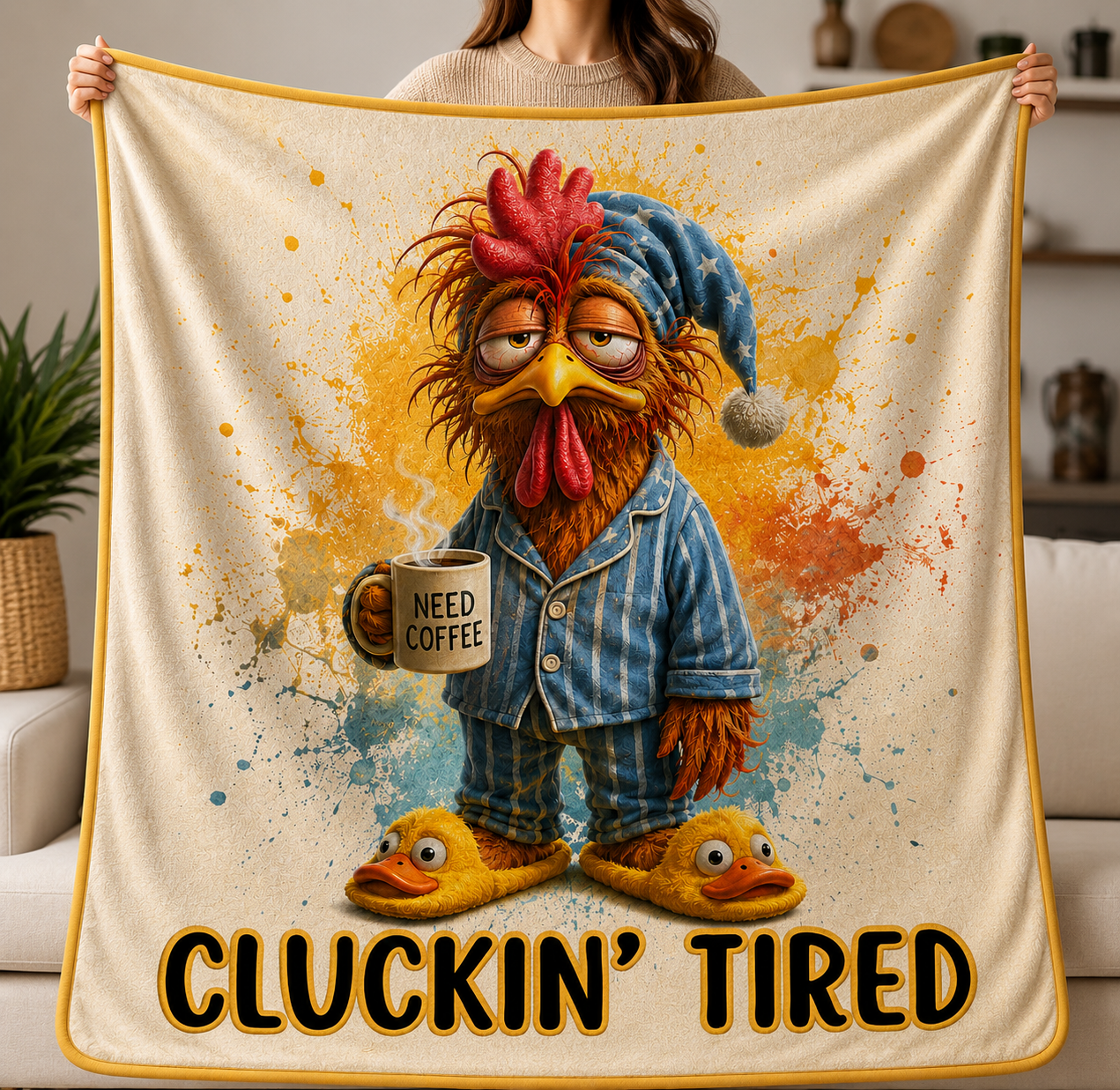 A person holds up a cream-colored fleece blanket with a colorful cartoon rooster wearing blue pajamas and holding a mug that says 'NEED COFFEE'. The blanket has a yellow border and the text 'CLUCKIN' TIRED' printed at the bottom.