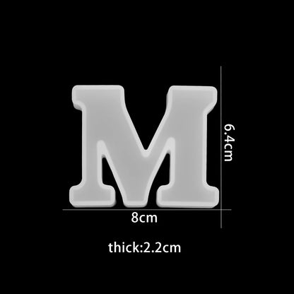 White letter 'M' with dimensions on a black background 8cm wide, 6.4cm high, 2.2cm thick