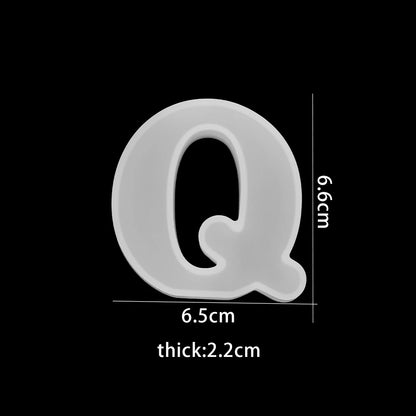 White letter 'Q' with measurements on a black background 6.5cm wide, 6.6cm high, 2.2cm thick