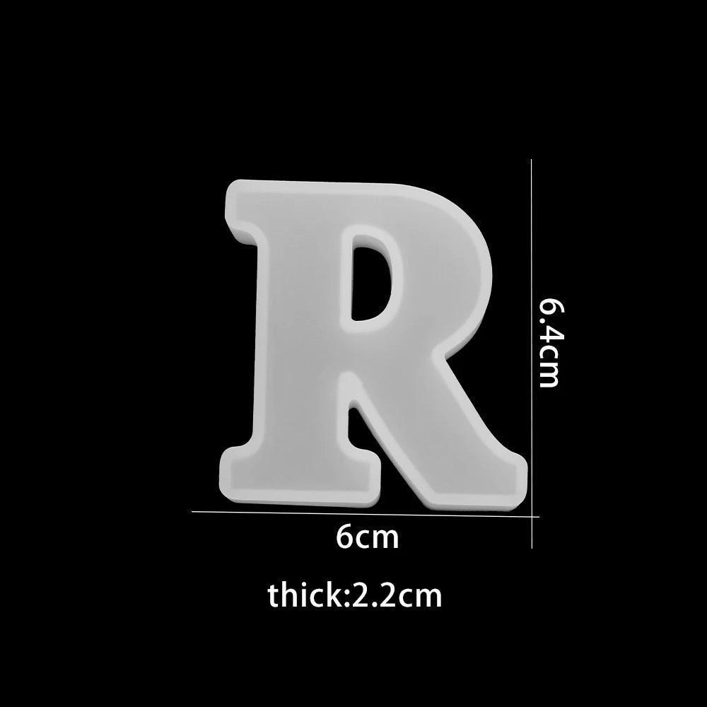 White letter 'R' with measurements on a black background 6cm wide, 6.4cm high 2.2cm thick