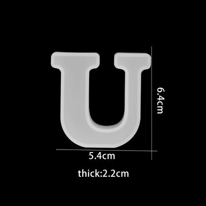 White letter 'U' with measurements on a black background 5.4 cm wide, 6.4 cm high, 2.2cm thick