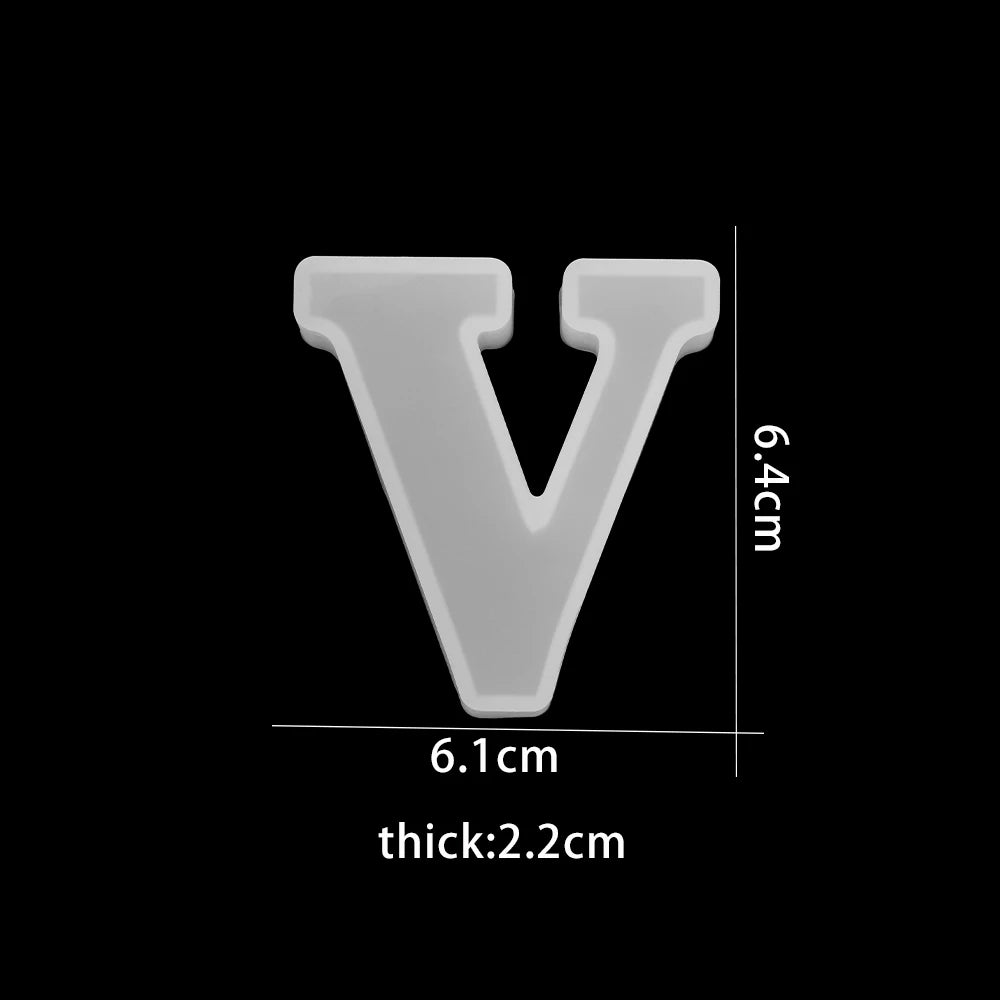 White letter 'V' with measurements on a black background 6.1cm wide, 6.4cm high, 2.2cm thick