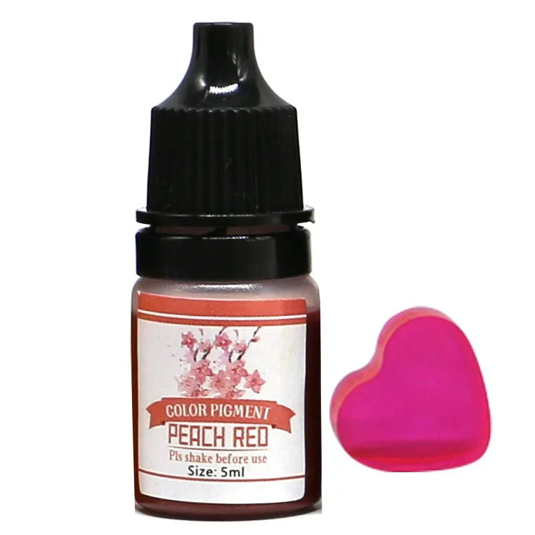 Bottle of peach red color pigment with a heart-shaped pink sponge on a white background