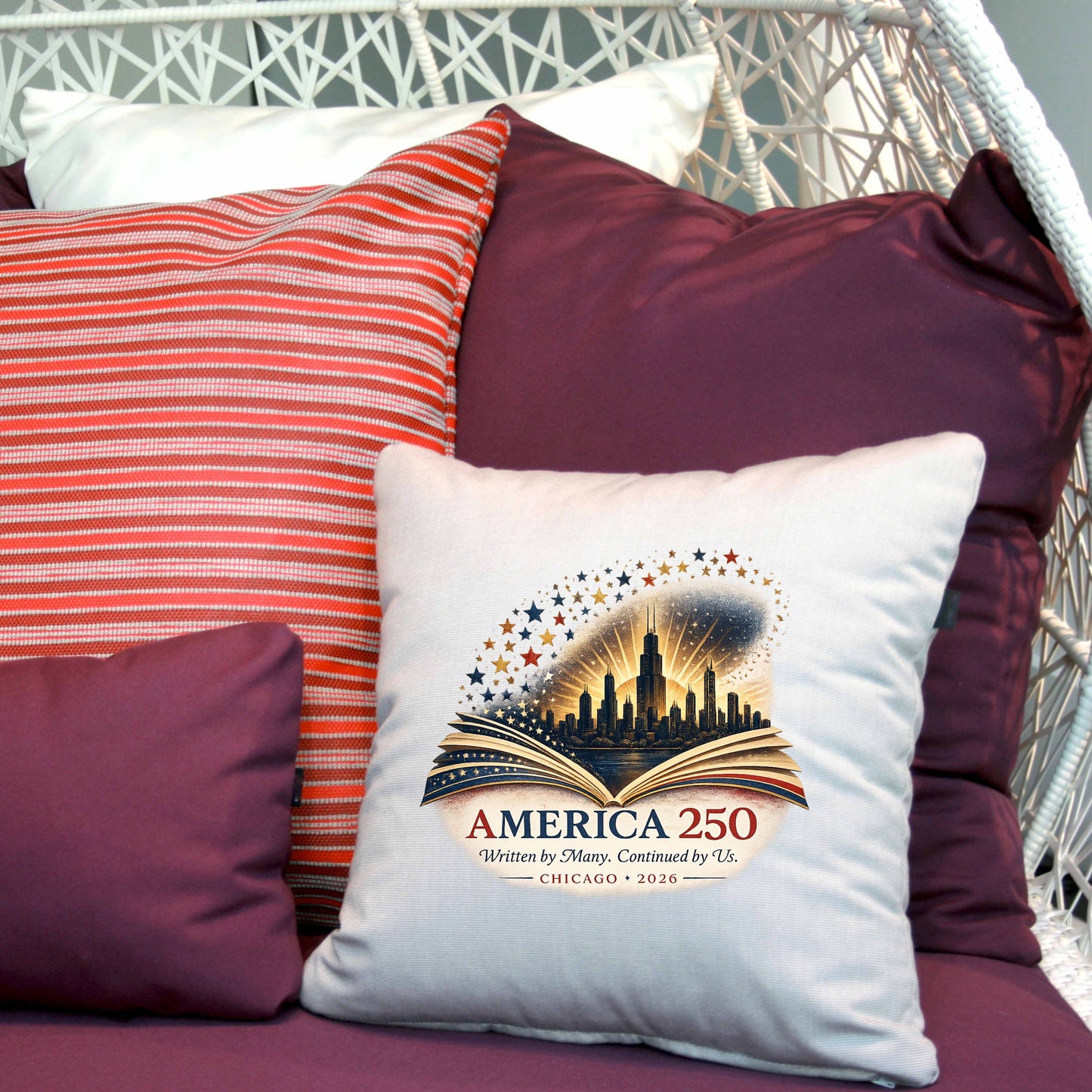 Decorative pillow with 'America 250' design on a chair with other pillows.