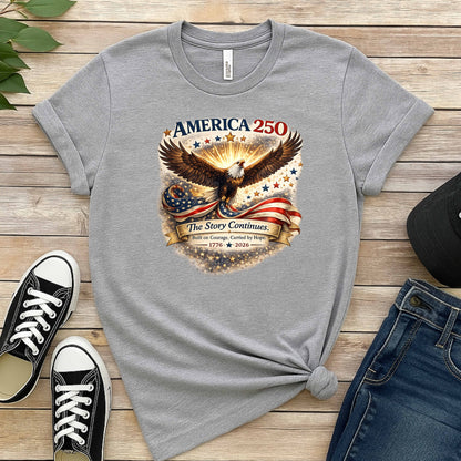 Gray t-shirt with eagle and American flag design on a wooden surface with shoes and jeans.