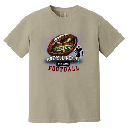 Bold football-themed graphic in Sandstone featuring a textured brown football with a glowing nighttime stadium and 50-yard line visible inside, a football player silhouette, watercolor background, and the words “ARE YOU READY FOR SOME FOOTBALL” in cream, black, and burgundy collegiate-style lettering.