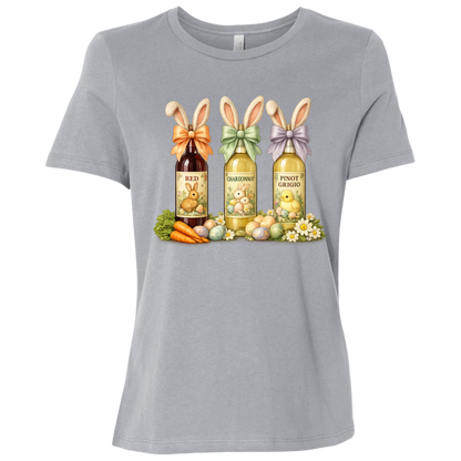Image of a Athletic Gray t-shirt with a colorful graphic design of three wine bottles (Red, Chardonnay, Pinot Grigio) with bows around the neck of the bottle and bunny ears posed in different positions at the top, flowers, a bunch of carrots and easter designed eggs are at the bottom surrounding the bottoms.