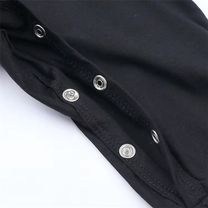 Close-up of a black garment with silver metal snap buttons along a seam, photographed on a white background.