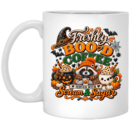 Halloween coffee design mug featuring a cozy raccoon in an orange knit hat and scarf surrounded by pumpkin spice drinks, pumpkins, bats, and autumn leaves, with the text “Freshly Boo'd Coffee” and “Scream & Sugar” on a transparent background