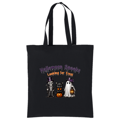 A black canvas tote bag with two shoulder straps, featuring a Halloween-themed graphic print on the front. The graphic reads 'Halloween Spooks Looking for Treats' in purple and orange dripping text above three cute cartoon characters: a skeleton in a top hat, a black cat in a bow tie holding a pumpkin, and a white ghost holding a lantern on a transparent background