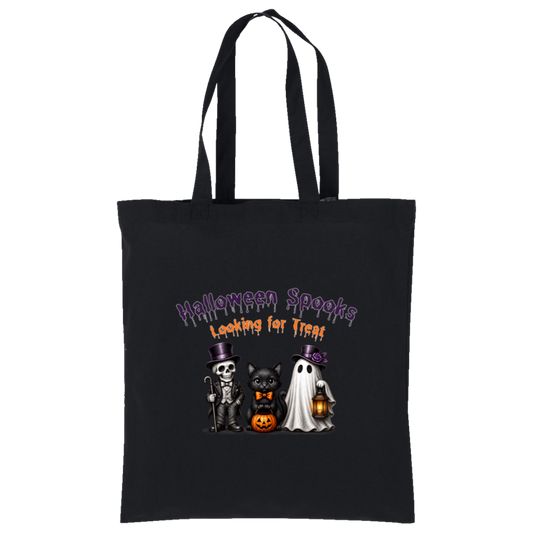 A black canvas tote bag with two shoulder straps, featuring a Halloween-themed graphic print on the front. The graphic reads 'Halloween Spooks Looking for Treats' in purple and orange dripping text above three cute cartoon characters: a skeleton in a top hat, a black cat in a bow tie holding a pumpkin, and a white ghost holding a lantern on a transparent background