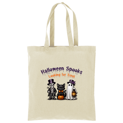 A natural canvas tote bag with two shoulder straps, featuring a Halloween-themed graphic print on the front. The graphic reads 'Halloween Spooks Looking for Treats' in purple and orange dripping text above three cute cartoon characters: a skeleton in a top hat, a black cat in a bow tie holding a pumpkin, and a white ghost holding a lantern on a transparent background