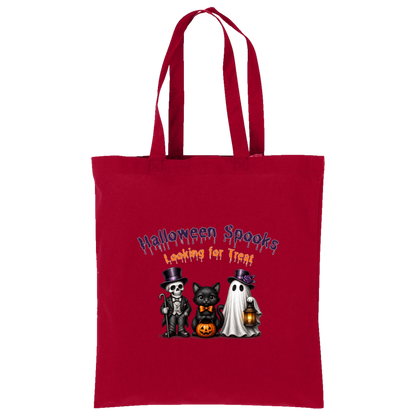 A red canvas tote bag with two shoulder straps, featuring a Halloween-themed graphic print on the front. The graphic reads 'Halloween Spooks Looking for Treats' in purple and orange dripping text above three cute cartoon characters: a skeleton in a top hat, a black cat in a bow tie holding a pumpkin, and a white ghost holding a lantern on a transparent background