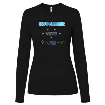 Long Sleeve Black blue and black November voting graphic with bold “NOVEMBER,” outlined “VOTE,” blue hearts, and the message “We are WORTH more than THIS,” accented with warm gold decorative marks on a transparent background.