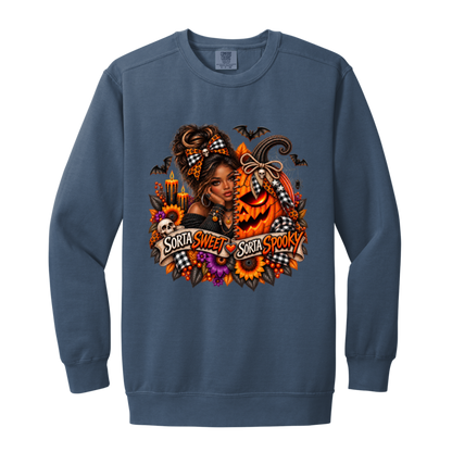 A Blue Jean Sweatshirt featuring an African American woman in a glamorous Halloween scene surrounded by a decorated jack-o'-lantern, sunflowers, autumn flowers, candles, bats, skulls, and spiderwebs, with a decorative banner reading “Sorta Sweet Sorta Spooky” on a transparent background