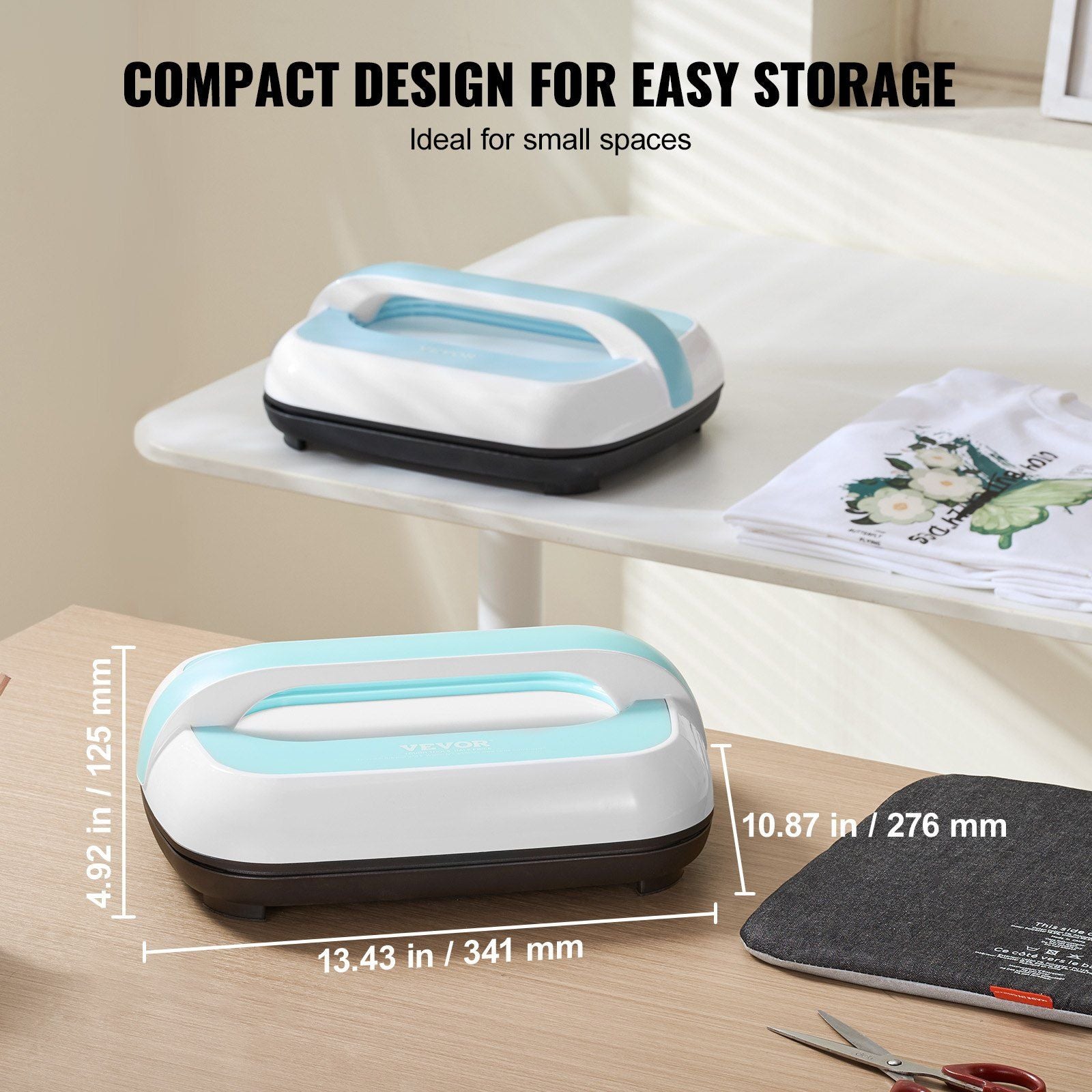 2 compact Vevor machines on on a white shelf with a stack of t-shirts and one on a wooden desk with dimensions 4.92 in x13.43 in x 10.87 in with scissors and a pad on the table