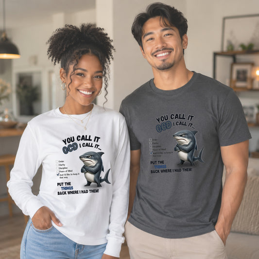 A man and a woman standing indoors wearing matching graphic t-shirts with a shark illustration and the text 'YOU CALL IT OCD I CALL IT.
