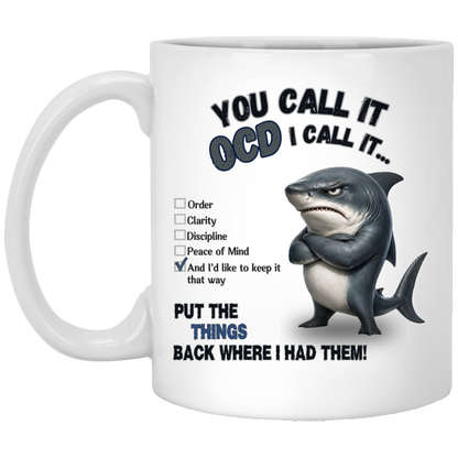 Realistic stern shark with crossed fins beside a checklist reading Order, Clarity, Discipline, Peace of Mind, and “And I’d like to keep it that way.” Text above reads “YOU CALL IT OCD I CALL IT…” and text below reads “PUT THE THINGS BACK WHERE I HAD THEM!” on a transparent background